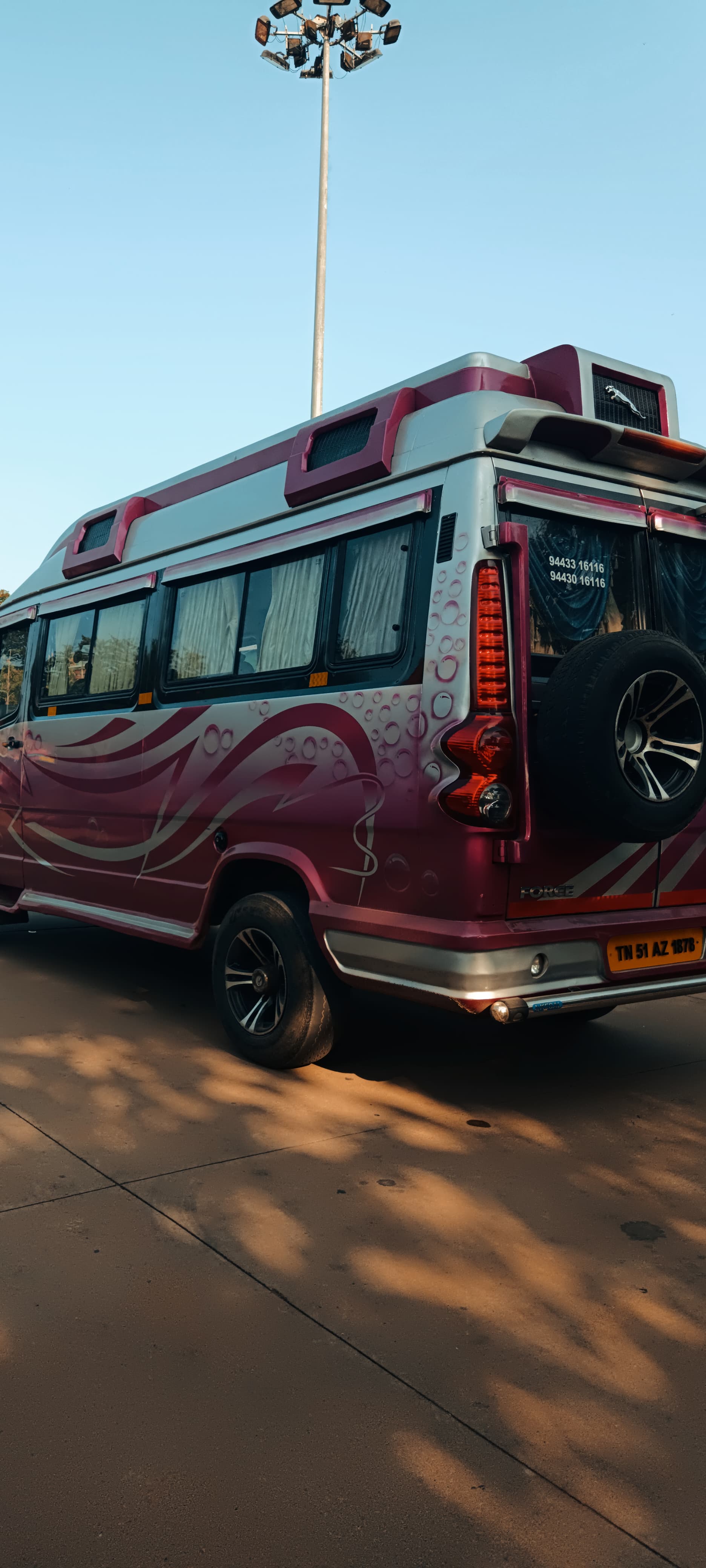 Rear side view of pink Tempo Traveller